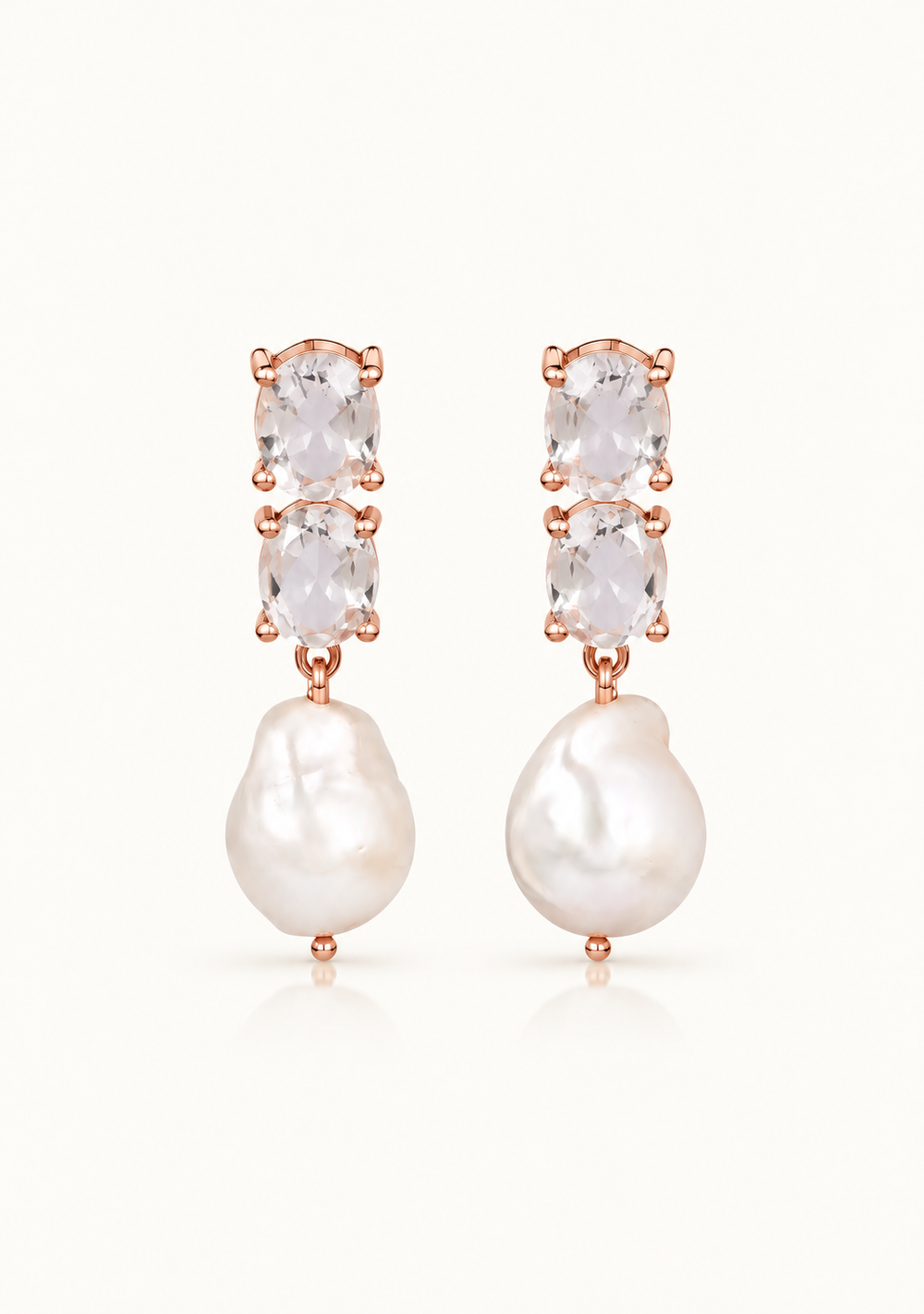 Rose gold drop earrings featuring three stacked clear marquise-cut crystals above a large, irregular white baroque pearl, shown on a clean off-white background.