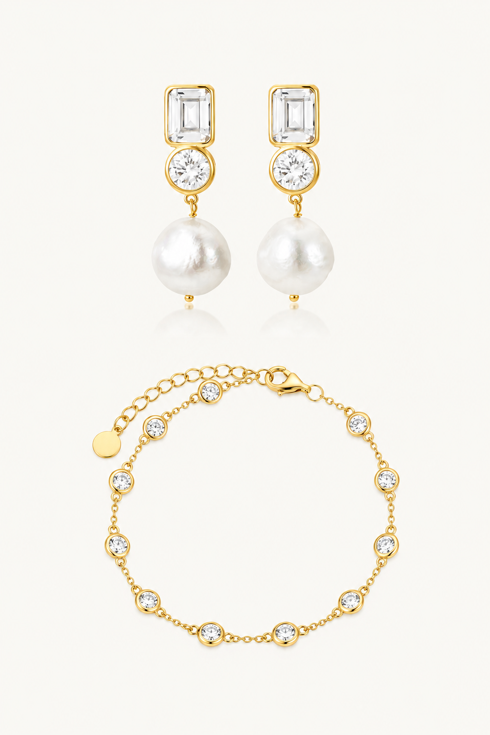 Gold jewelry set featuring a pair of drop earrings and a matching bracelet, each with a rectangular clear gemstone, a round clear stone, and a white pearl or pearl-like bead, displayed on a light cream background.