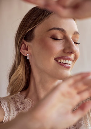 
                  
                    Load image into Gallery viewer, Woman wearing diamond earrings with a neutral background
                  
                