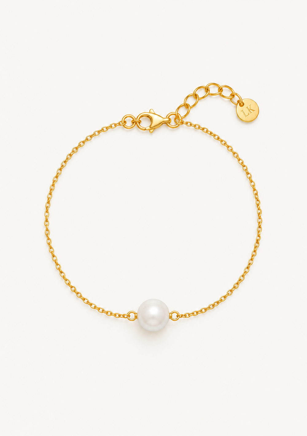 A delicate gold chain bracelet featuring a single white pearl bead at the center, displayed on a clean off-white background.