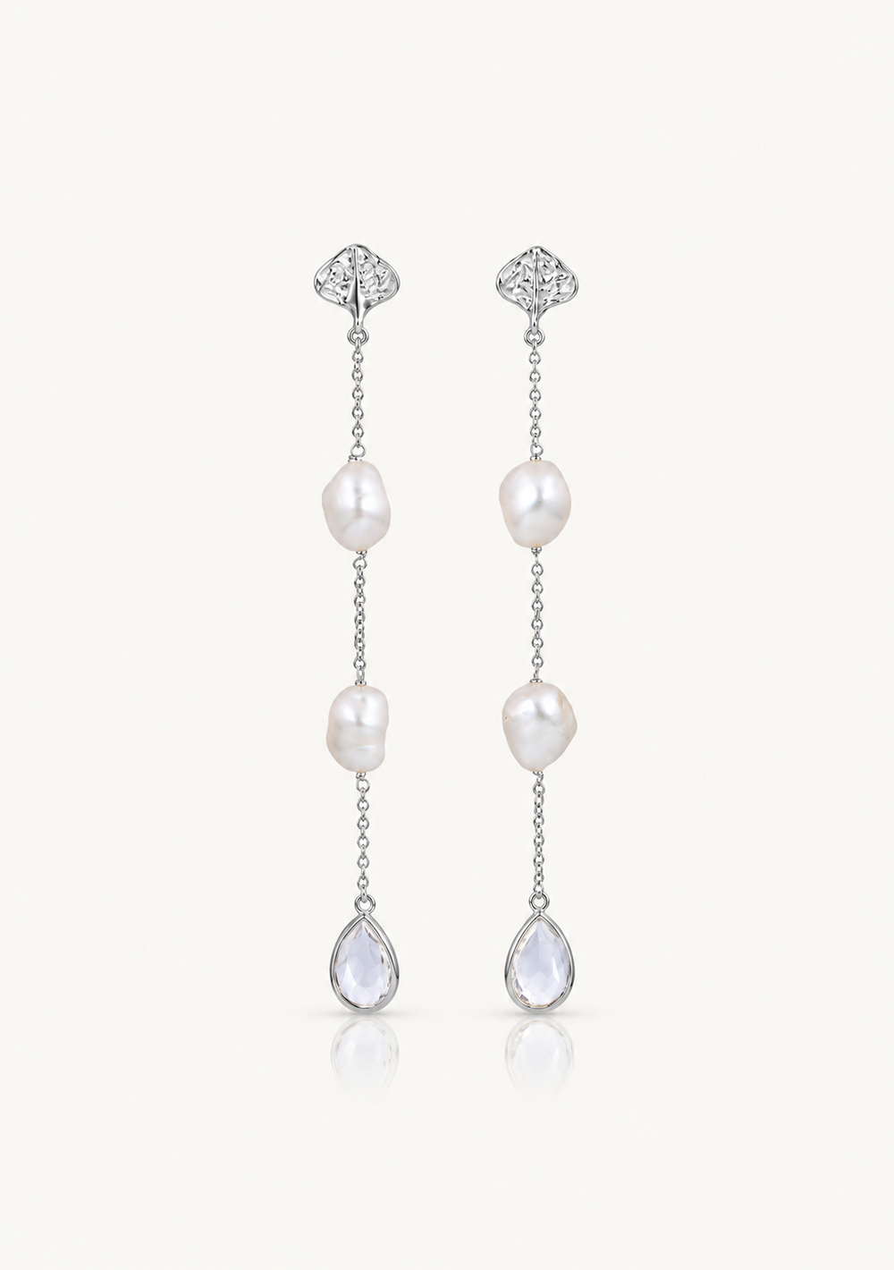 A pair of silver drop earrings featuring baroque pearls and clear teardrop crystals, displayed on a clean off-white background.