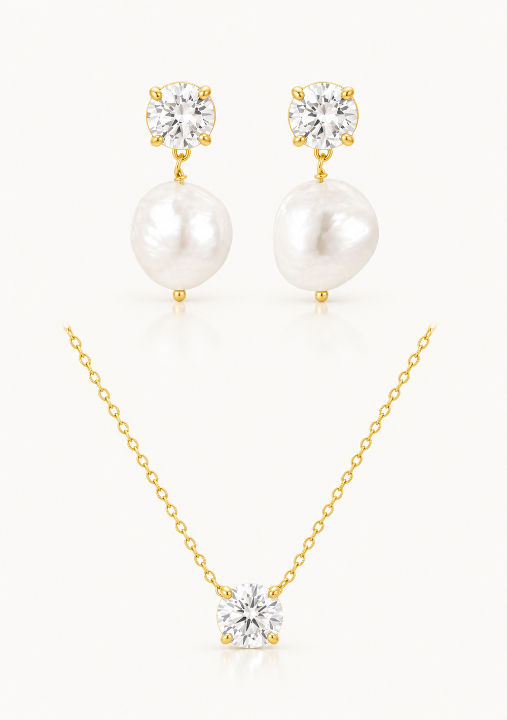 A jewelry set featuring a gold necklace with a clear round-cut stone pendant, matching gold stud earrings with large white baroque pearls and clear stones, and a gold chain necklace with a clear round-cut stone pendant, all arranged on a light cream background.